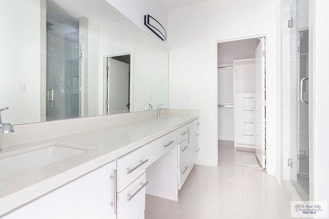 bathroom with tile patterned flooring, vanity, and a shower with shower door