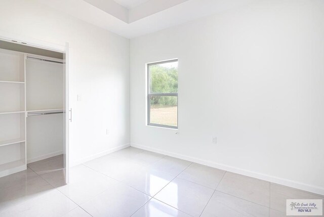 unfurnished bedroom featuring light tile patterned floors and a closet