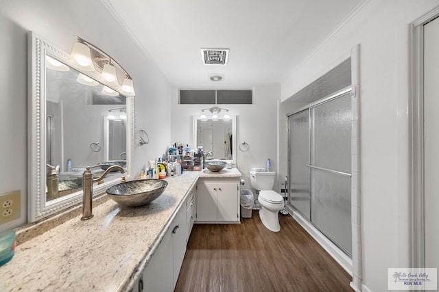 bathroom with vanity, wood-type flooring, walk in shower, and ornamental molding