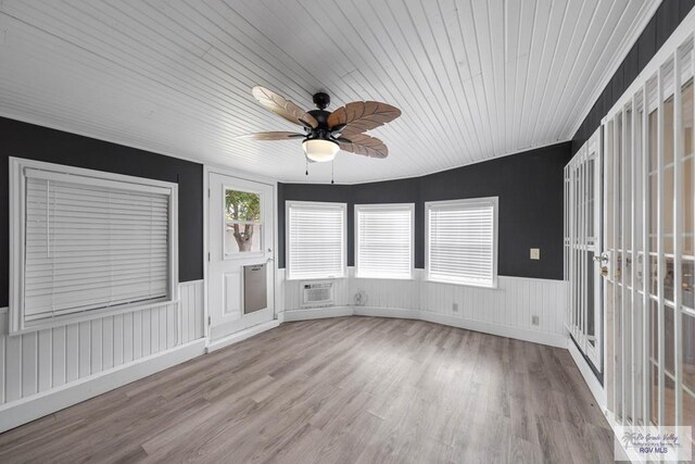 unfurnished sunroom featuring a wall mounted air conditioner, ceiling fan, and wood ceiling