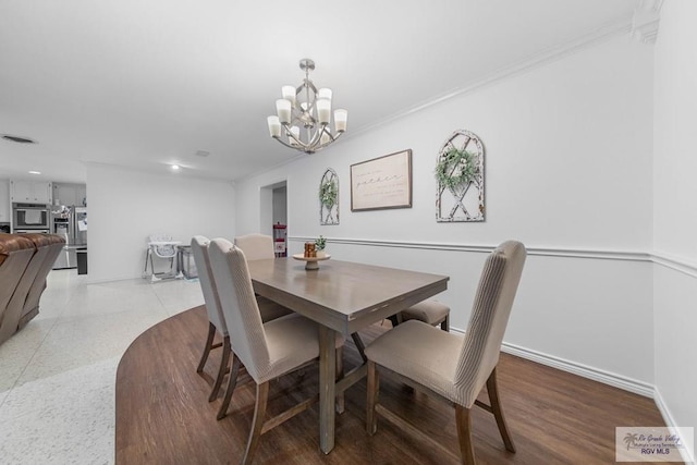 dining space featuring hardwood / wood-style flooring, a notable chandelier, and ornamental molding