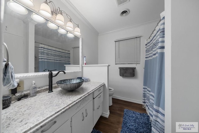 bathroom featuring vanity, hardwood / wood-style flooring, toilet, and crown molding