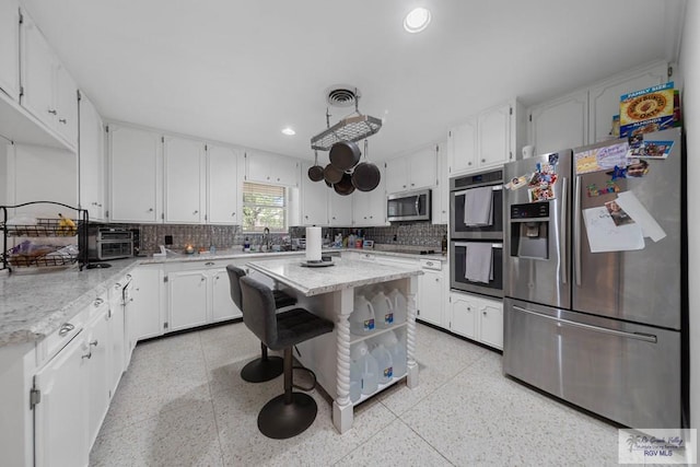 kitchen with white cabinetry, a center island, sink, and appliances with stainless steel finishes