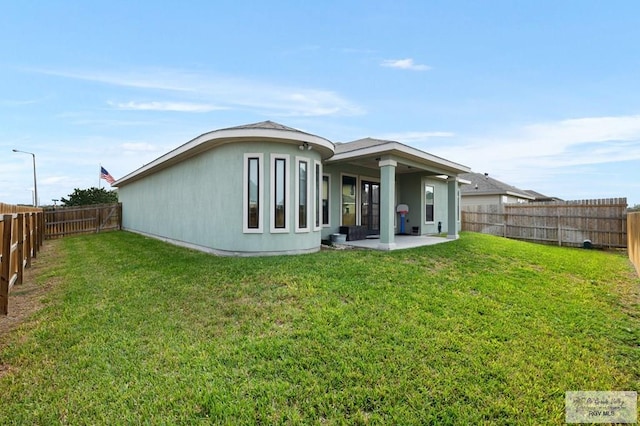 rear view of property with a patio area and a yard