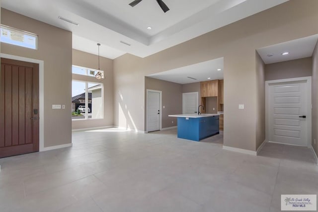 interior space with a high ceiling, sink, and ceiling fan