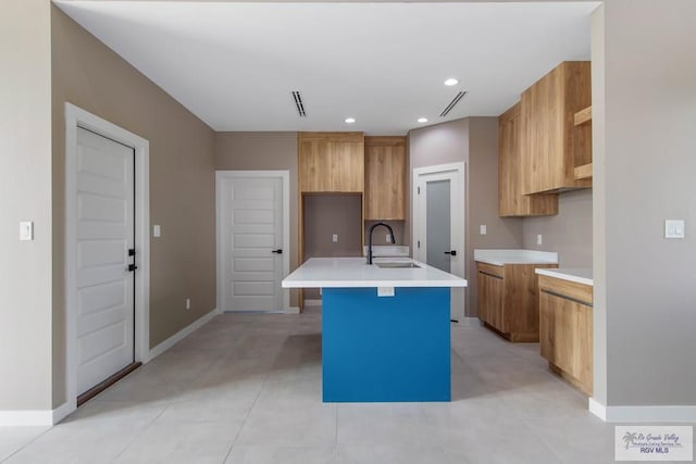 kitchen with sink and an island with sink