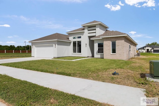 prairie-style home featuring a garage, a front lawn, and central air condition unit