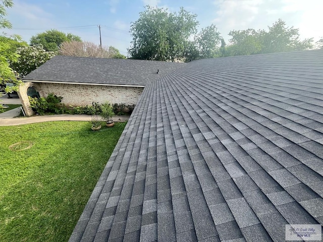exterior details featuring roof with shingles