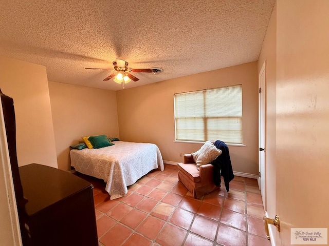 tiled bedroom with a textured ceiling and ceiling fan