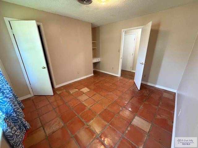 unfurnished bedroom with a textured ceiling