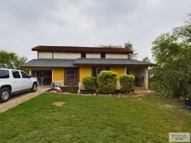 view of front of house featuring a garage and a front lawn