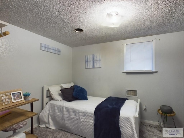 bedroom featuring carpet floors and a textured ceiling