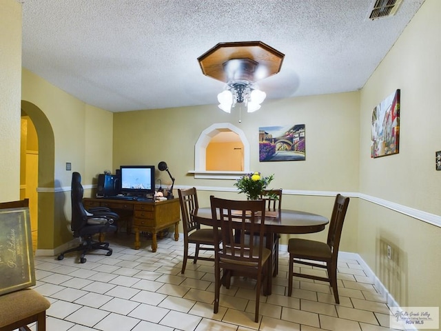 dining space featuring ceiling fan and a textured ceiling