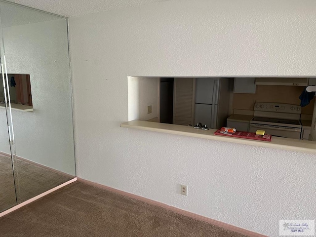 2901 Central Blvd, Brownsville, TX 78520 - kitchen with white range with electric cooktop, carpet flooring, and baseboards