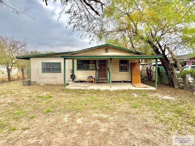 view of front facade with entry steps, a patio, a front lawn, and fence