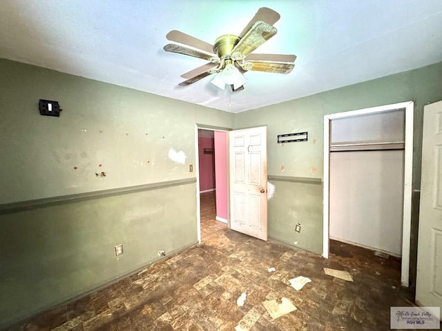 unfurnished bedroom featuring ceiling fan and a closet