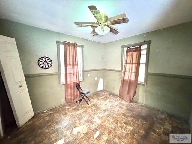 spare room with a ceiling fan and a healthy amount of sunlight