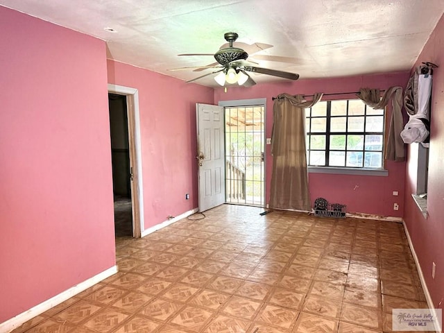 empty room featuring a healthy amount of sunlight, baseboards, and a ceiling fan