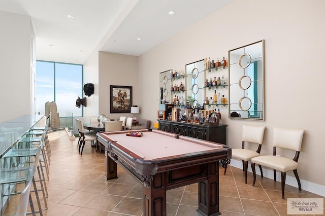 game room featuring bar area, a wall of windows, light tile patterned floors, and billiards