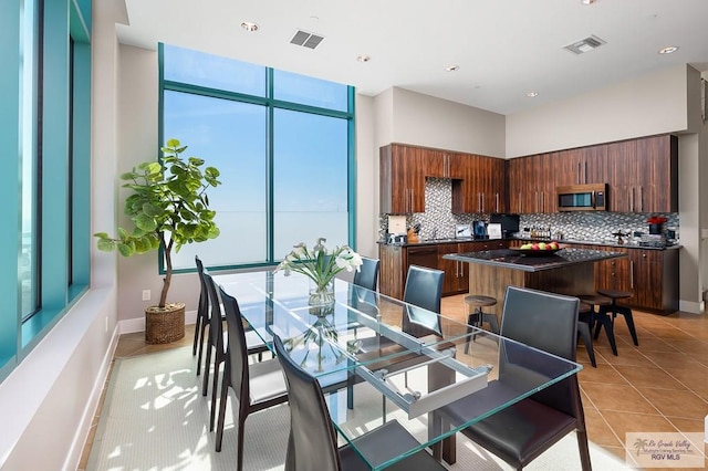 tiled dining area featuring a healthy amount of sunlight