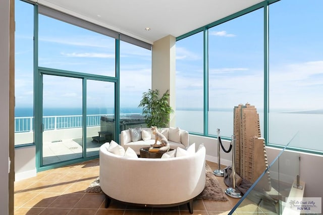 tiled living room with expansive windows and a water view