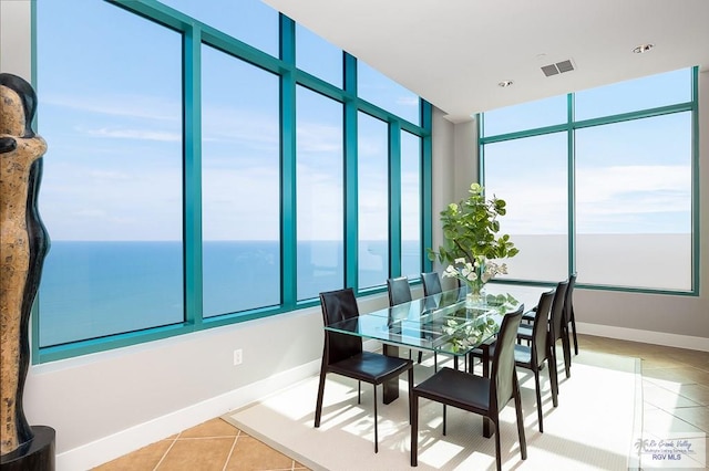 tiled dining space with a water view and a healthy amount of sunlight