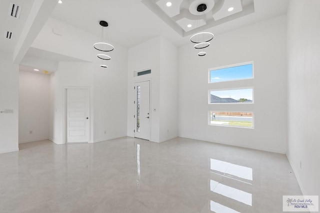 interior space featuring a towering ceiling and a raised ceiling