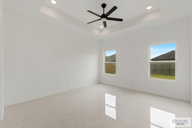 unfurnished room with a raised ceiling and ceiling fan