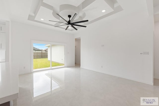 spare room featuring ceiling fan and a tray ceiling