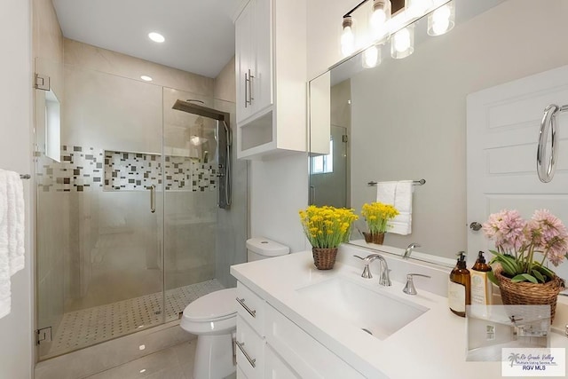 bathroom with an enclosed shower, vanity, tile patterned floors, and toilet