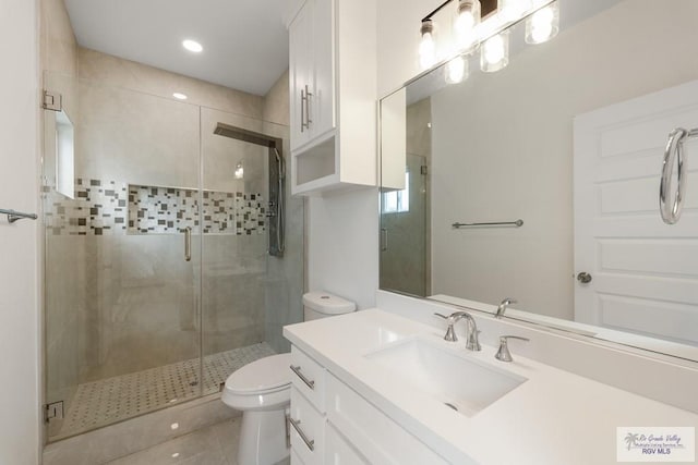 bathroom with tile patterned flooring, vanity, toilet, and walk in shower