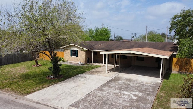 ranch-style house with an attached carport, brick siding, fence, driveway, and a front yard