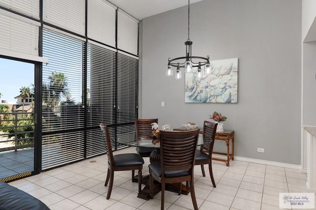 tiled dining room with a towering ceiling and an inviting chandelier