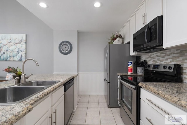 kitchen featuring light stone counters, sink, white cabinets, and stainless steel appliances