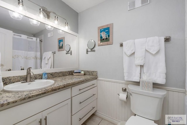 bathroom featuring tile patterned floors, vanity, and toilet