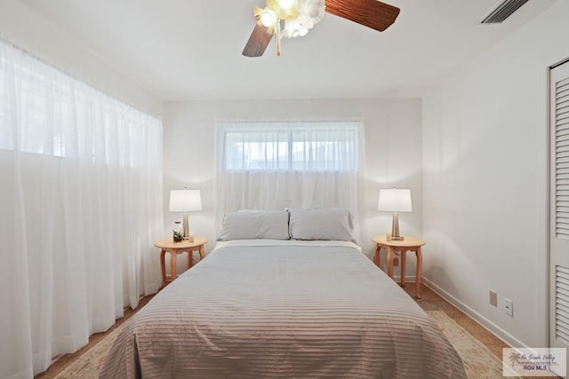 bedroom featuring a ceiling fan, visible vents, and baseboards