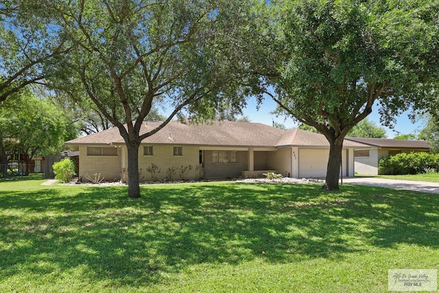 ranch-style home with brick siding, fence, a garage, a front lawn, and concrete driveway