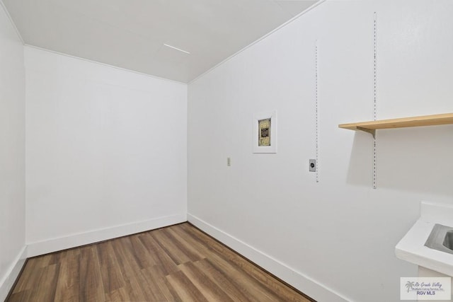 clothes washing area featuring electric dryer hookup, wood finished floors, laundry area, and baseboards