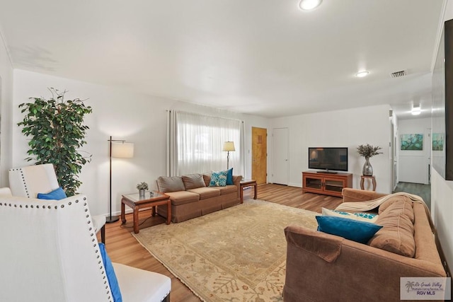 living room with recessed lighting, visible vents, wood finished floors, and baseboards