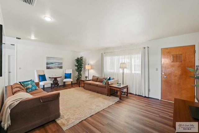 living room featuring visible vents and wood finished floors