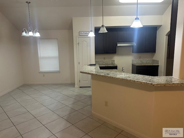 kitchen with a notable chandelier, lofted ceiling, pendant lighting, light stone counters, and light tile patterned floors