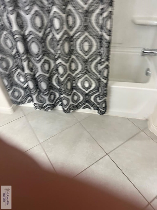 bathroom featuring tile patterned floors and shower / bath combo with shower curtain