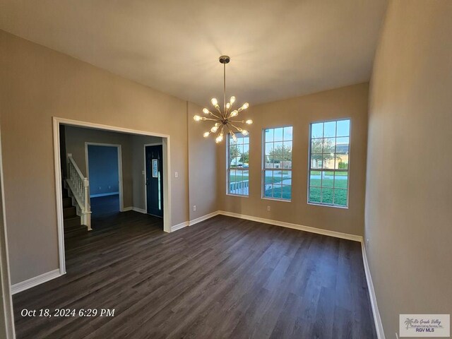 27406 Kelly Ct, La Feria, TX 78559 - unfurnished dining area featuring a chandelier, dark wood-style flooring, baseboards, and stairway