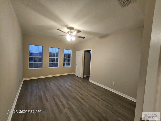 unfurnished room featuring a ceiling fan, baseboards, and dark wood-style floors