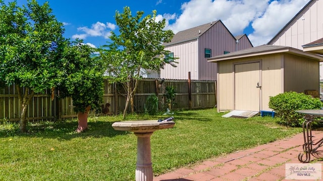 view of yard with a shed, fence, and an outbuilding