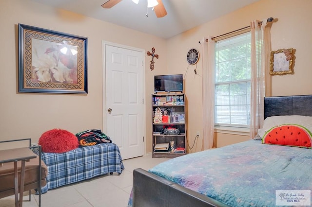 tiled bedroom featuring ceiling fan