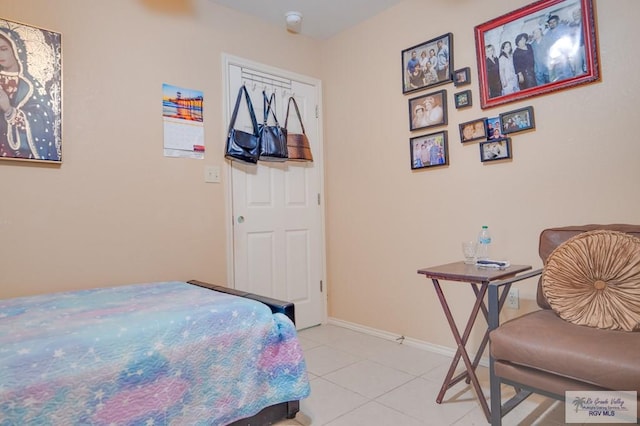 bedroom with light tile patterned floors and baseboards