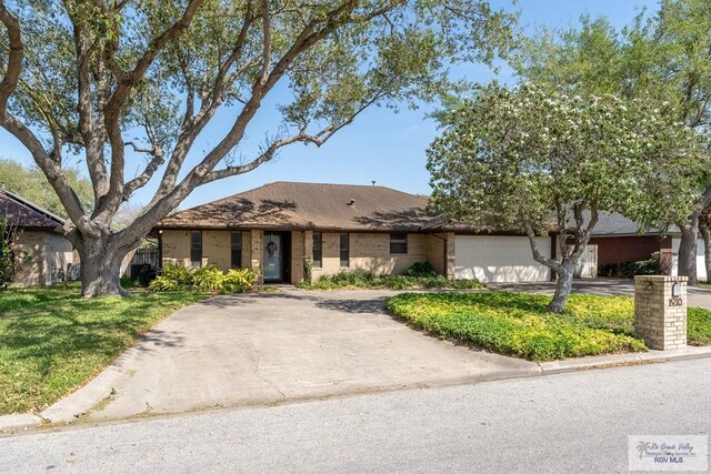1916 Loquat Dr, Harlingen, TX 78552 - view of front of property with asphalt driveway, a garage, and brick siding