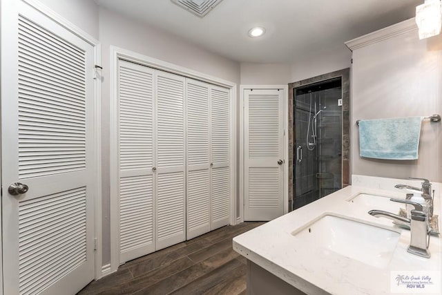 1916 Loquat Dr, Harlingen, TX 78552 - bathroom with a closet, wood finished floors, double vanity, a stall shower, and recessed lighting