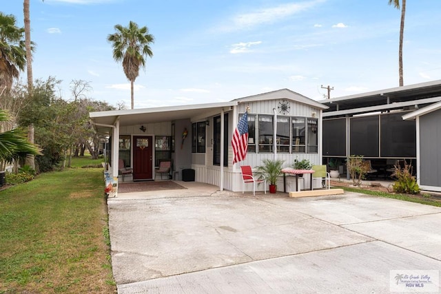 view of front of house featuring a sunroom and a front yard